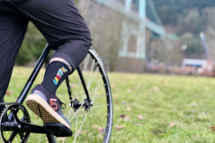 The Grateful Socks are designed to inspire positivity and gratitude, featuring the word "Grateful" prominently displayed. Ideal for cycling, running, and cross-training, these socks combine style and performance. Available in oatmeal with blue text and blue with white text. Made in the USA with recycled fibers, they offer both durability and sustainability