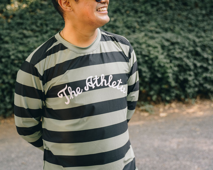 The Men's Stripes Tech Tee is a long-sleeve, moisture-wicking shirt designed for colder runs or gravel rides. Featuring a bold stripe pattern, this limited-run tee pairs well with The Athletic's iceberg socks, Death Palm, or El Sol designs. Crafted in California from Italian fabrics by Endo Customs, it offers both style and performance for active individuals