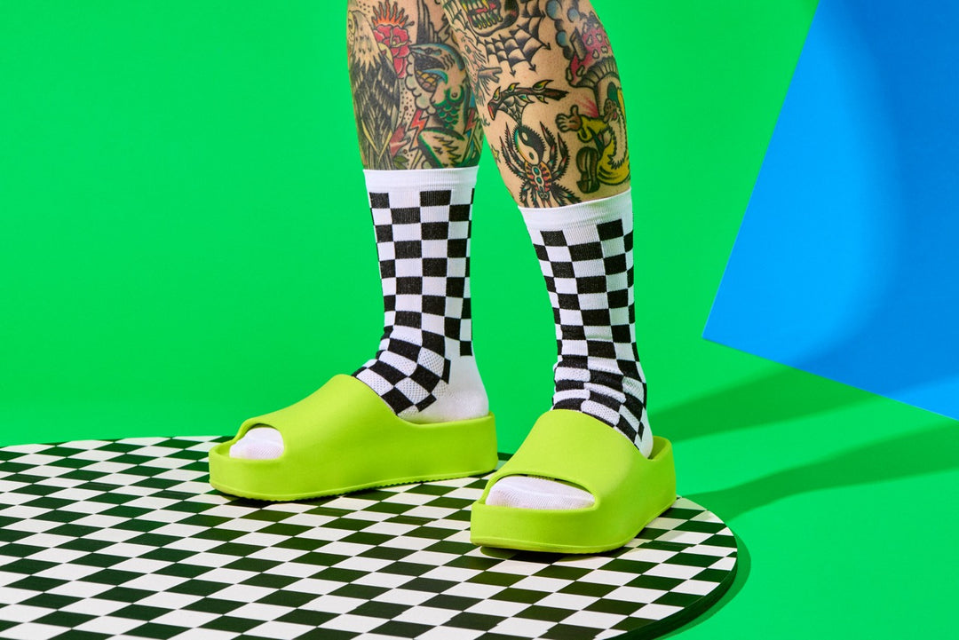 The SUPER TUFF Check Yourself Socks feature a bold checkerboard pattern, adding a rebellious flair to your athletic wear. Crafted for durability and comfort, these socks are perfect for activities like running, cycling, or hitting the gym. Made in the USA with recycled fibers, they combine style, performance, and sustainability