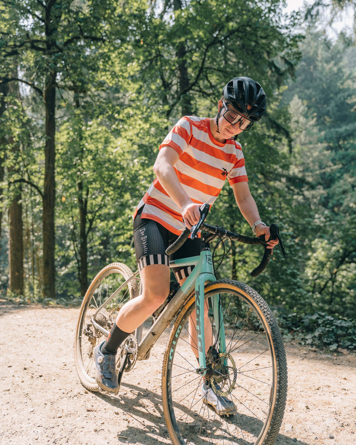 The Women's Waldo Short Sleeve Tech Tee is a versatile performance shirt designed for activities like running, cycling, and cross-training. Crafted in California from Italian-engineered fabrics, it features a lightweight, breathable design with a split side seam at the hem to accommodate lower body movement. This timeless striped tee, adorned with a black rose on the upper left chest, offers both style and functionality for active individuals