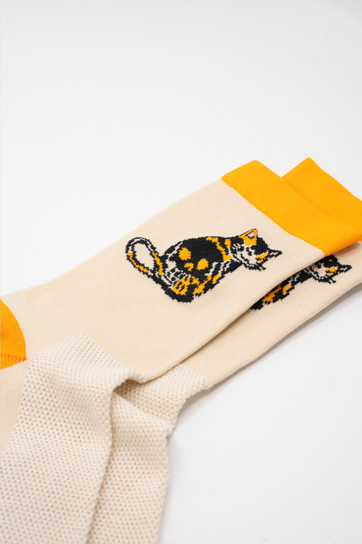 The Skull Kitty Socks, designed by artist Jake Tong, feature a playful calico cat skull design. These limited edition socks are perfect for cycling, running, and cross-training. Made in the USA with love, they combine style and performancePerfect sock for running, hiking or cycling, or the gym. Made in the USA from recycled fibers.