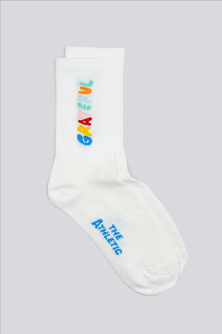 The Grateful Socks are designed to inspire positivity and gratitude, featuring the word "Grateful" prominently displayed. Ideal for cycling, running, and cross-training, these socks combine style and performance. Available in oatmeal with blue text and blue with white text. Made in the USA with recycled fibers, they offer both durability and sustainability