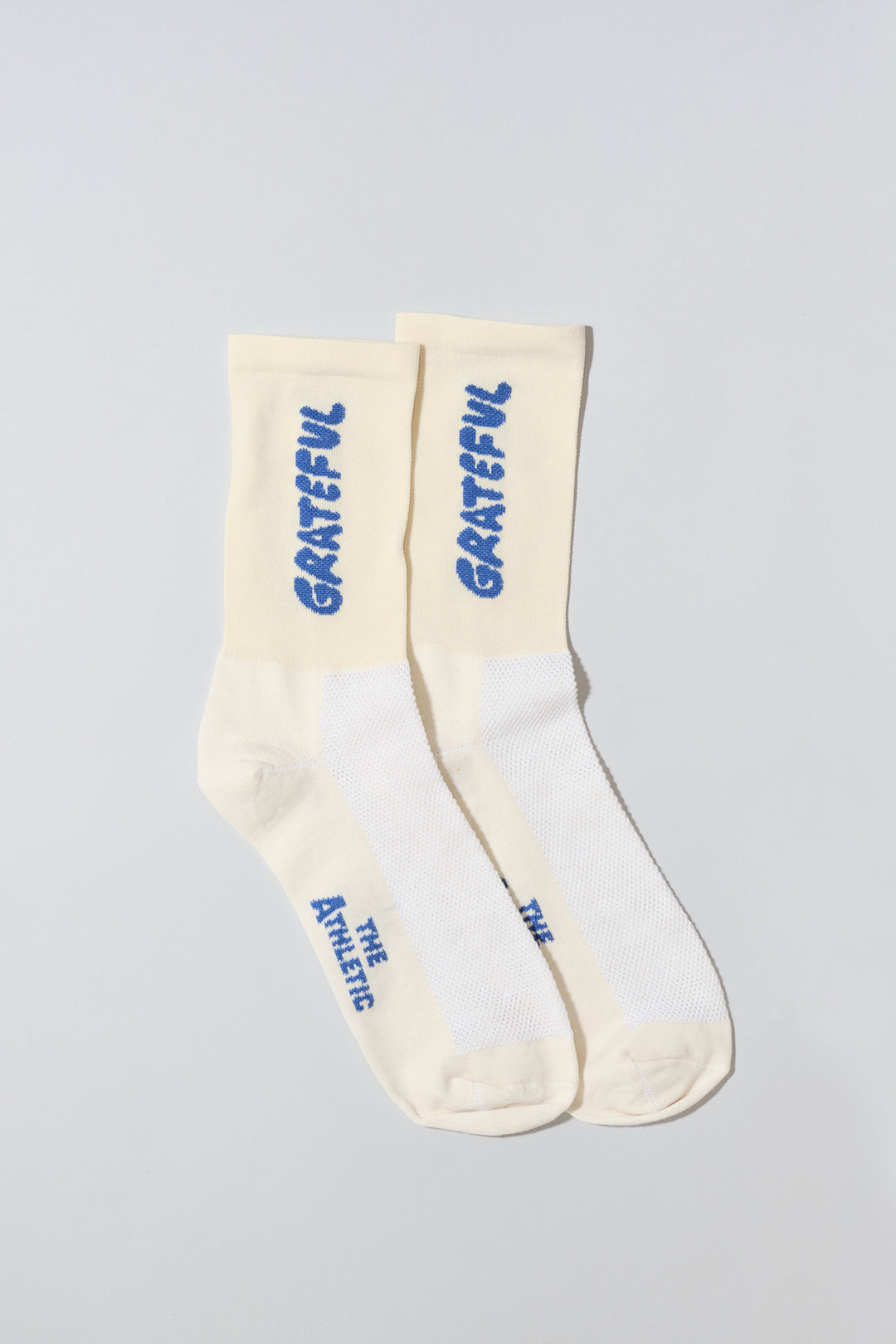 The Grateful Socks are designed to inspire positivity and gratitude, featuring the word "Grateful" prominently displayed. Ideal for cycling, running, and cross-training, these socks combine style and performance. Available in oatmeal with blue text and blue with white text. Made in the USA with recycled fibers, they offer both durability and sustainability