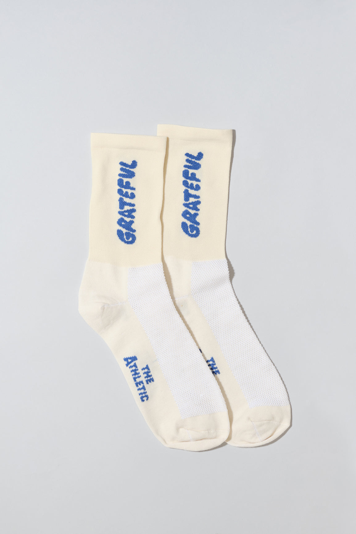 Oatmeal socks with "Grateful" text written in blue.