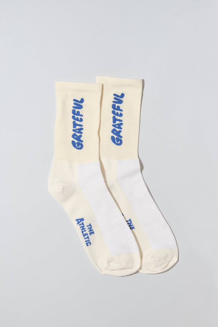 Oatmeal socks with "Grateful" text written in blue.