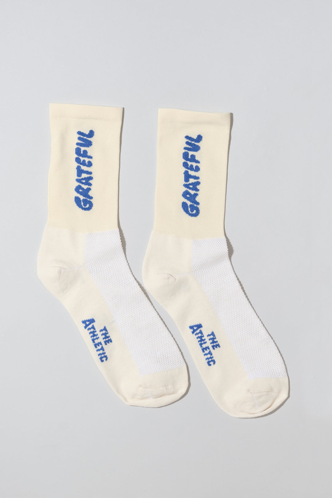 The Grateful Socks are designed to inspire positivity and gratitude, featuring the word "Grateful" prominently displayed. Ideal for cycling, running, and cross-training, these socks combine style and performance. Available in oatmeal with blue text and blue with white text. Made in the USA with recycled fibers, they offer both durability and sustainability