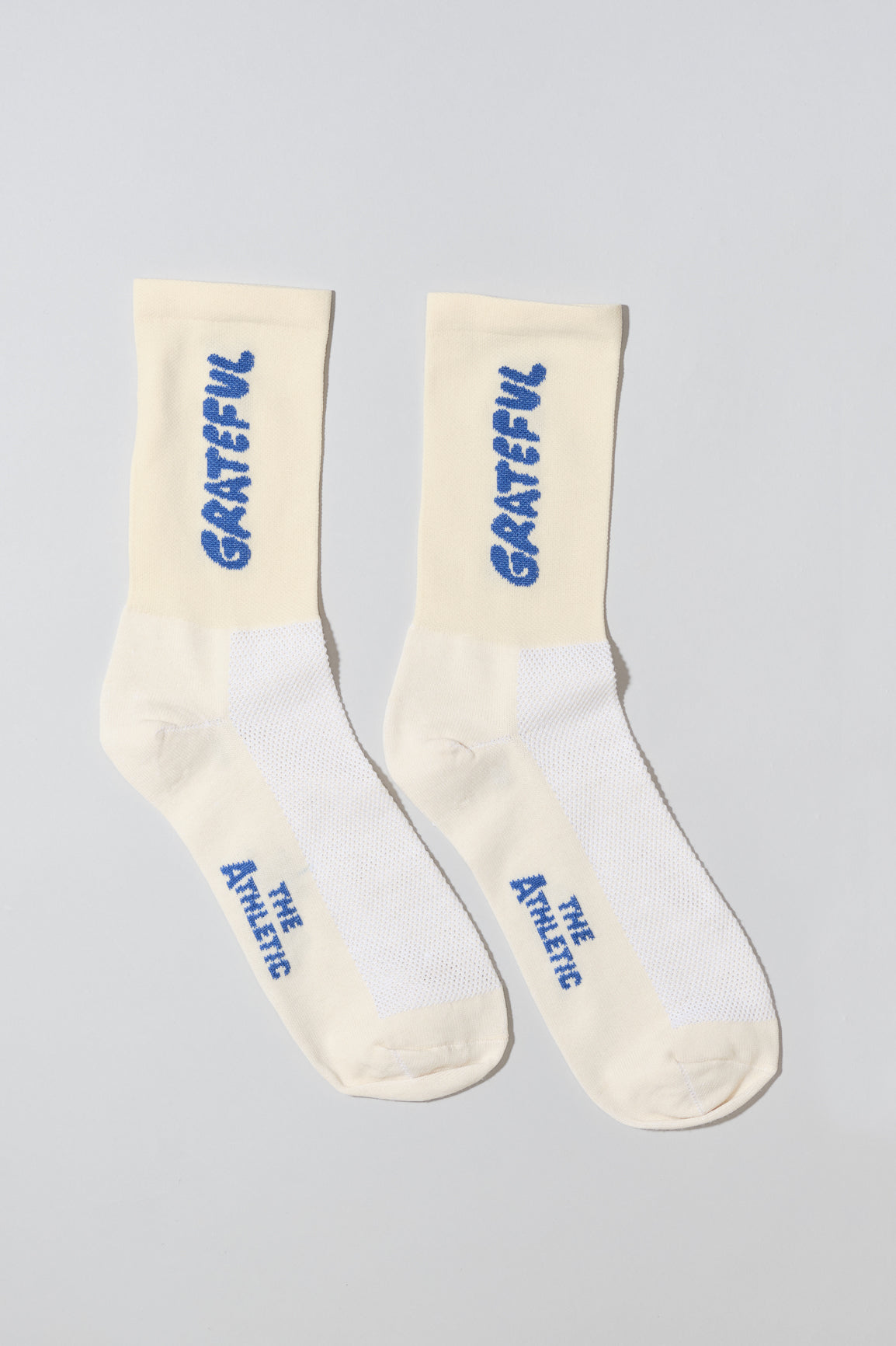 Oatmeal socks with "Grateful" text written in blue.