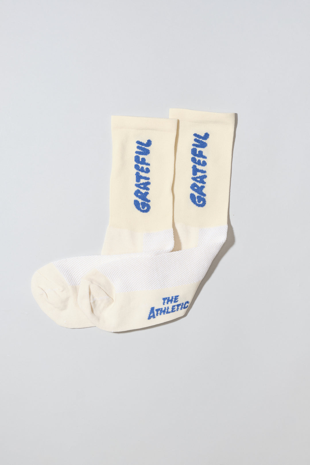 The Grateful Socks are designed to inspire positivity and gratitude, featuring the word "Grateful" prominently displayed. Ideal for cycling, running, and cross-training, these socks combine style and performance. Available in oatmeal with blue text and blue with white text. Made in the USA with recycled fibers, they offer both durability and sustainability