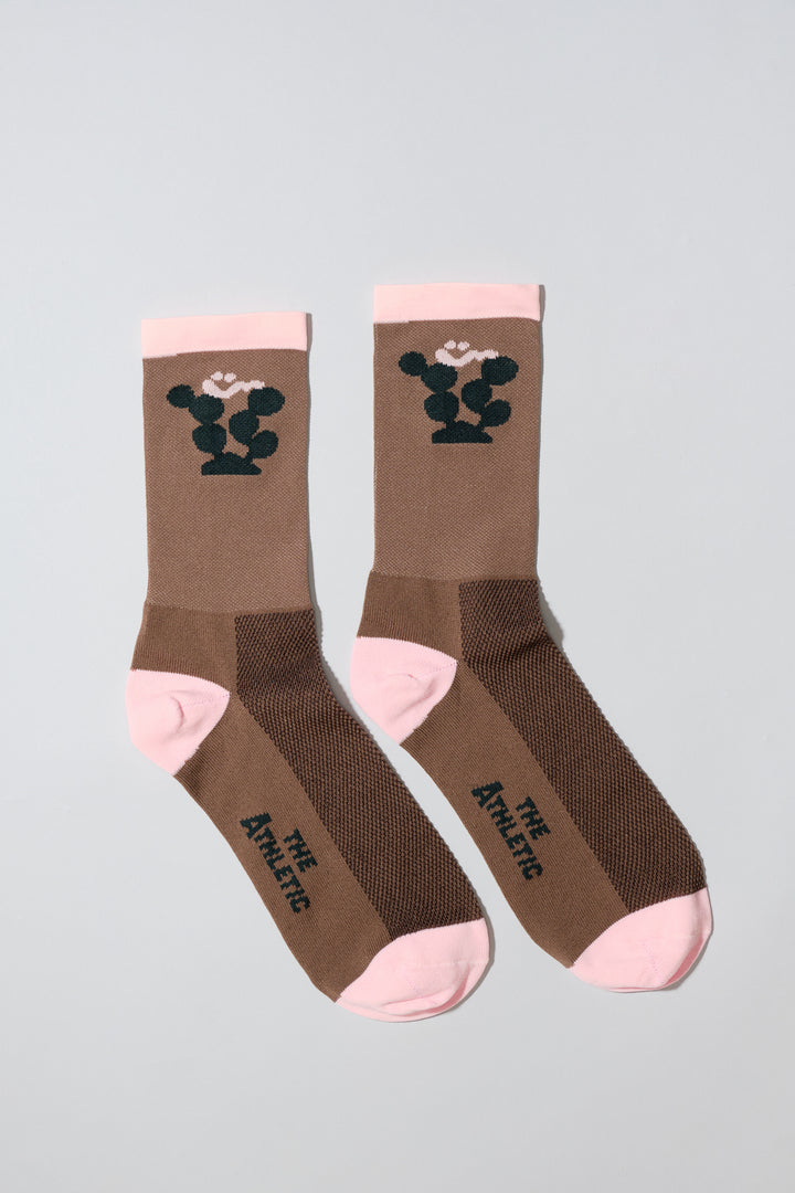 The Happy Cactus Socks, designed by artist Will Bryant, feature a playful cactus and smiley face design. Made in the USA with love, these socks are perfect for adding a touch of fun to your athletic wear. Ideal for cycling, running, and casual wear, they combine style and performance