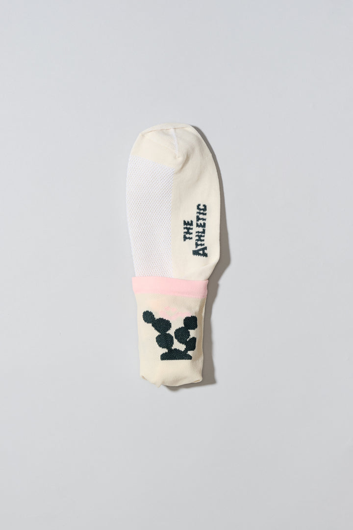 The Happy Cactus Socks, designed by artist Will Bryant, feature a playful cactus and smiley face design. Made in the USA with love, these socks are perfect for adding a touch of fun to your athletic wear. Ideal for cycling, running, and casual wear, they combine style and performance