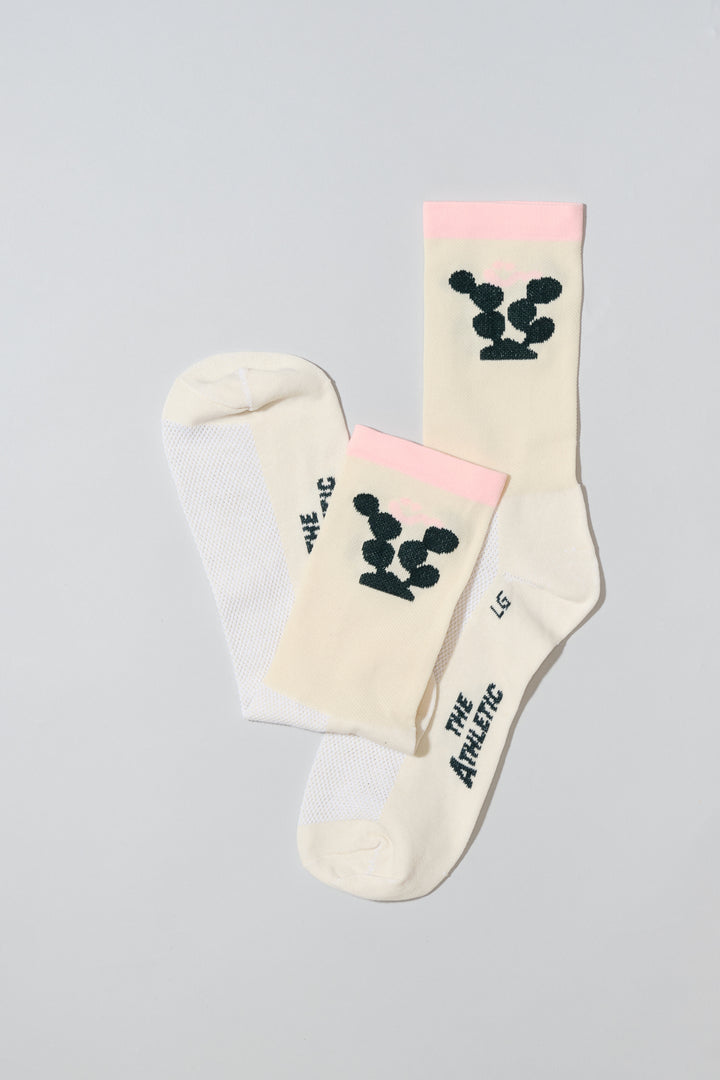 The Happy Cactus Socks, designed by artist Will Bryant, feature a playful cactus and smiley face design. Made in the USA with love, these socks are perfect for adding a touch of fun to your athletic wear. Ideal for cycling, running, and casual wear, they combine style and performance